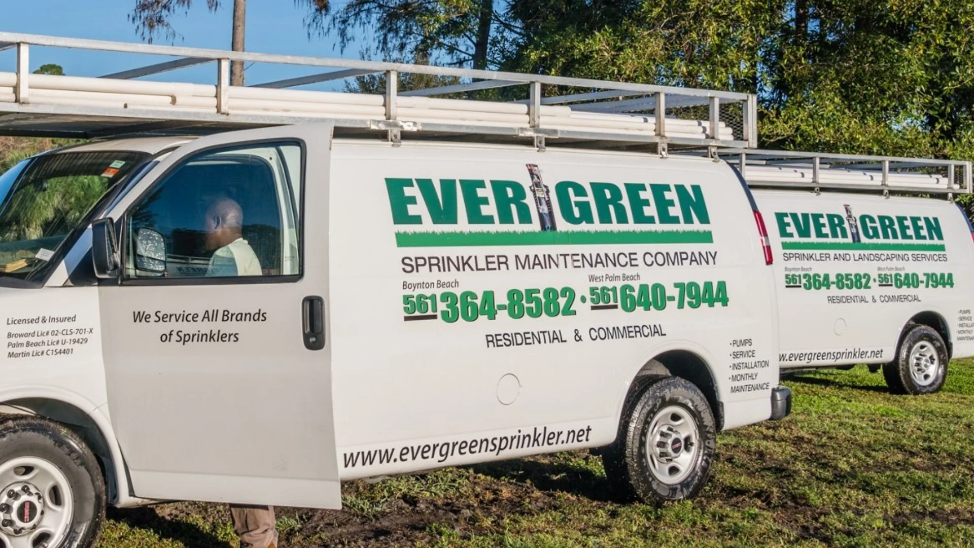 Evergreen company vehicles on grass in West Palm Beach, FL.